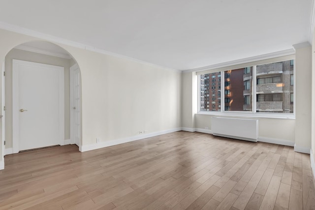 61 W 62nd St Unit 12G, New York City, NY 10023 - unfurnished room with radiator, arched walkways, wood finished floors, ornamental molding, and baseboards