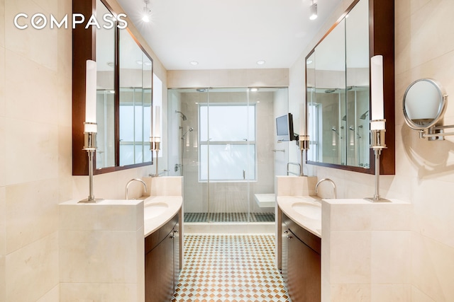 full bathroom featuring a sink, a stall shower, and two vanities