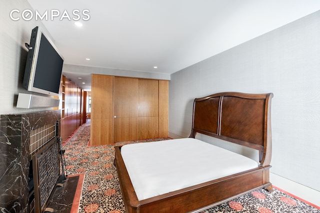 bedroom featuring recessed lighting and a fireplace with flush hearth