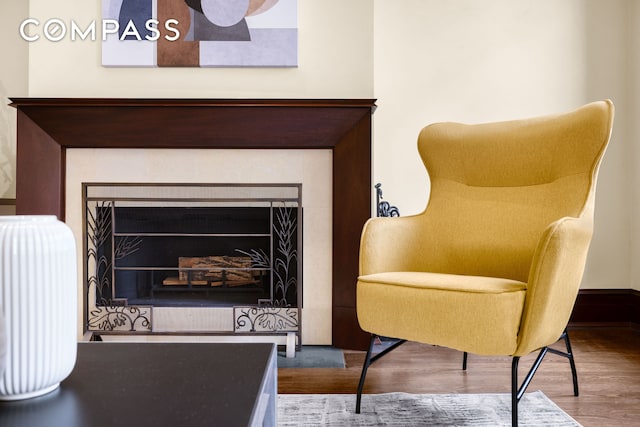 sitting room with a fireplace and wood finished floors