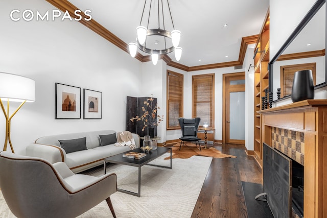 living area with baseboards, a fireplace, dark wood finished floors, and crown molding