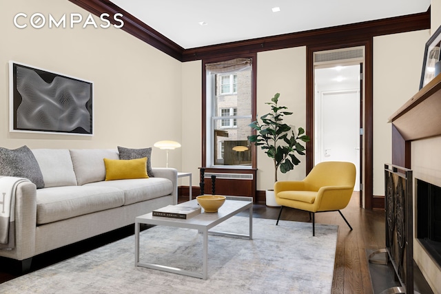 living area featuring crown molding, baseboards, and wood finished floors