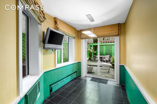 interior space with dark tile patterned floors and a baseboard radiator