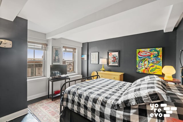 bedroom with beam ceiling and baseboards