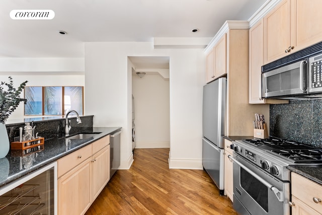24 W 45th St Unit 7, New York City, NY 10036 - kitchen with stainless steel appliances, beverage cooler, backsplash, light wood-type flooring, and dark stone counters