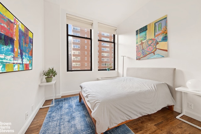 bedroom with baseboards and wood finished floors