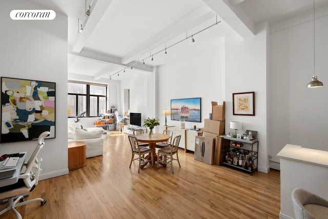 dining room featuring visible vents, beam ceiling, light wood-style flooring, track lighting, and baseboard heating