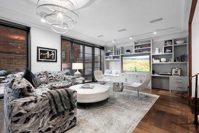 living area featuring rail lighting, wood finished floors, an inviting chandelier, and ornamental molding