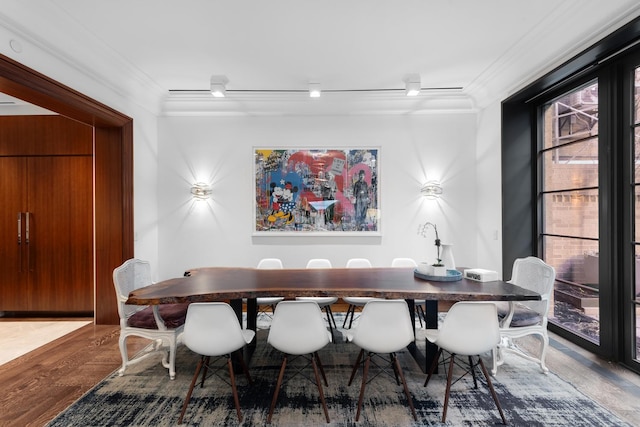 dining area with wood finished floors and ornamental molding