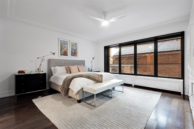 bedroom featuring crown molding, ceiling fan, and dark wood finished floors