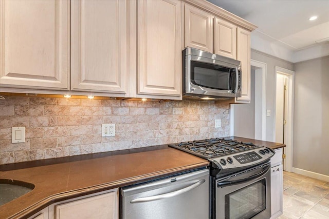 kitchen featuring dark countertops, recessed lighting, appliances with stainless steel finishes, decorative backsplash, and baseboards