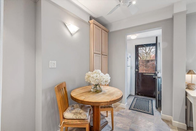 dining area with stone finish flooring, baseboards, and a ceiling fan