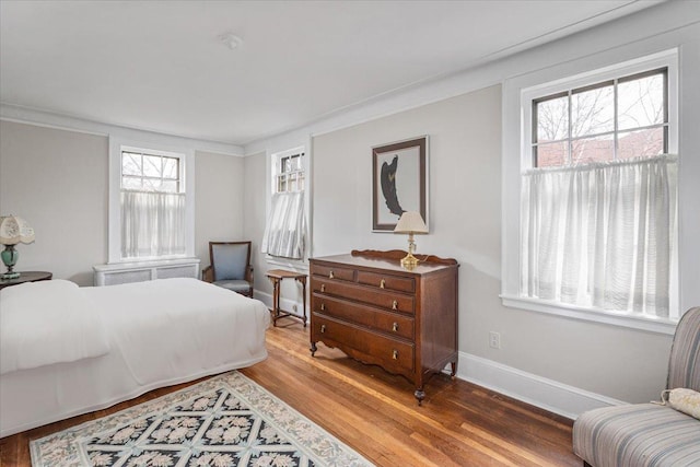 bedroom with baseboards and wood finished floors