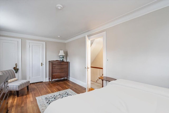 bedroom featuring ornamental molding, baseboards, and hardwood / wood-style flooring