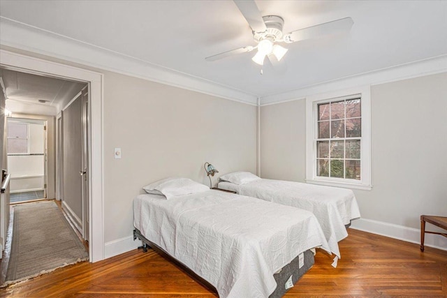 bedroom featuring ceiling fan, crown molding, baseboards, and wood finished floors