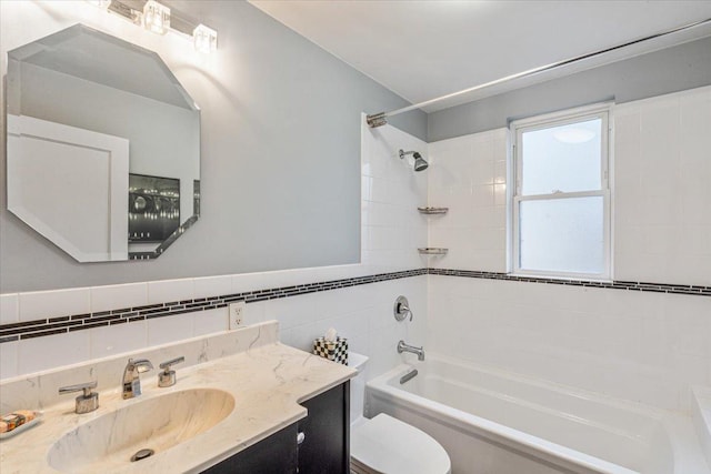 full bath with vanity, tile walls, toilet, and shower / bath combination