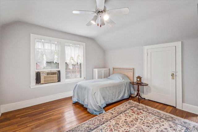 bedroom featuring lofted ceiling, cooling unit, wood finished floors, and baseboards