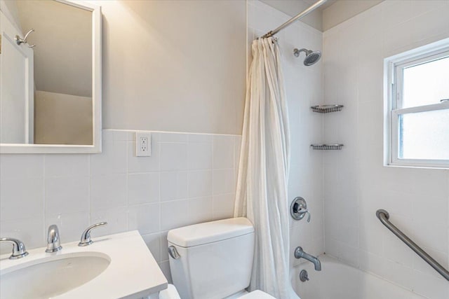 full bath with tile walls, vanity, toilet, and shower / tub combo