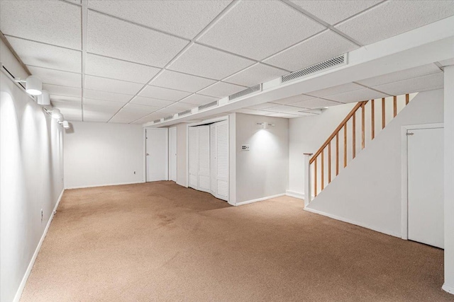 finished basement with visible vents, carpet flooring, a paneled ceiling, and baseboards