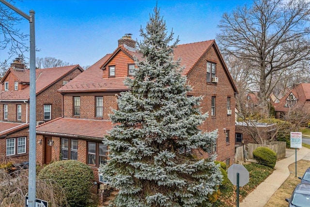 view of front of home featuring brick siding and a chimney