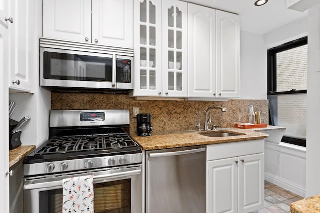 kitchen with a sink, white cabinetry, and stainless steel appliances