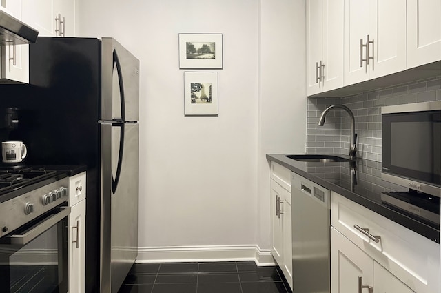 kitchen with a sink, stainless steel appliances, under cabinet range hood, dark countertops, and backsplash