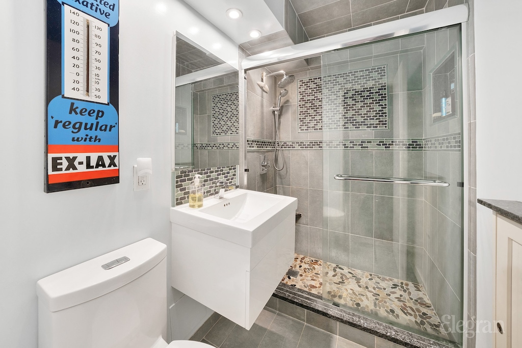 full bath featuring recessed lighting, toilet, a stall shower, and vanity