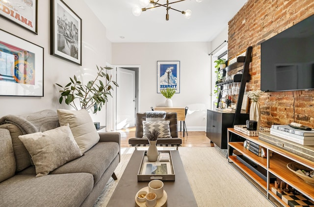 315 E 12th St Unit 22, New York City, NY 10003 - living area featuring brick wall, wood finished floors, a chandelier, and baseboards
