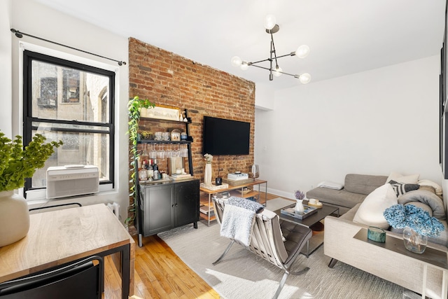 315 E 12th St Unit 22, New York City, NY 10003 - living area with an inviting chandelier, wood finished floors, and brick wall