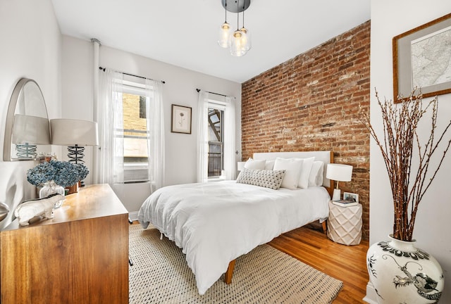 315 E 12th St Unit 22, New York City, NY 10003 - bedroom featuring light wood-type flooring and brick wall