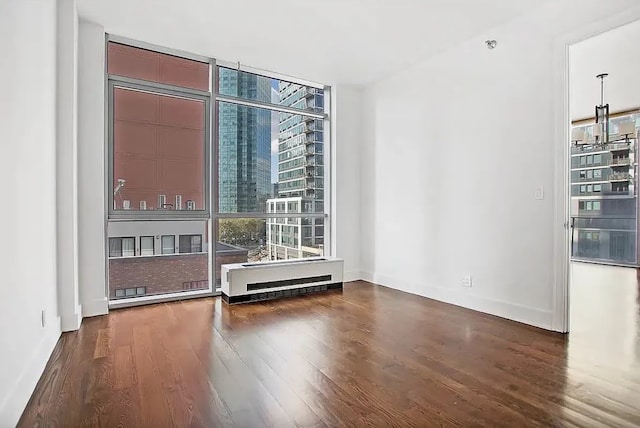 empty room with a wall of windows and wood finished floors