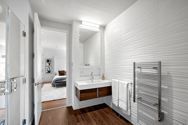 bathroom with radiator, wood finished floors, vanity, and ensuite bathroom