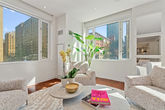 sitting room featuring visible vents, baseboards, and wood finished floors