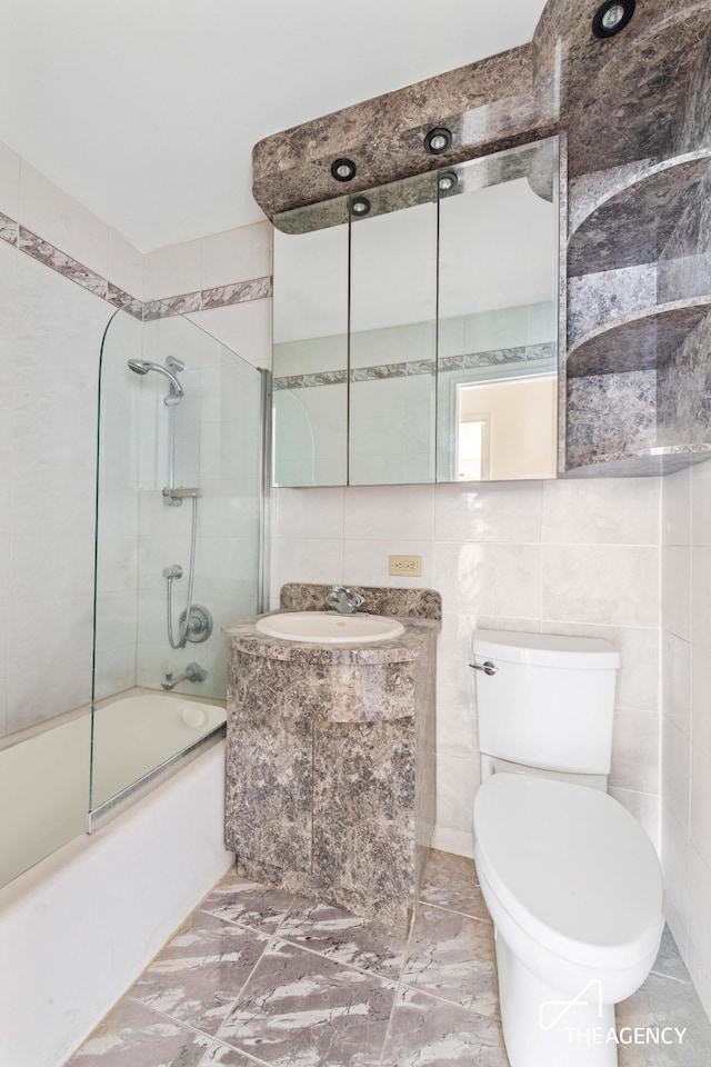 142 W End Ave Unit 6U, New York City, NY 10023 - bathroom with tile walls, bath / shower combo with glass door, toilet, and vanity