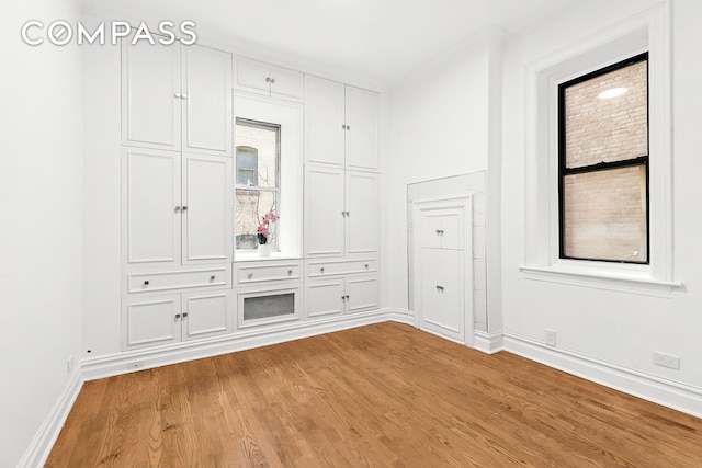 spare room featuring baseboards and light wood-type flooring