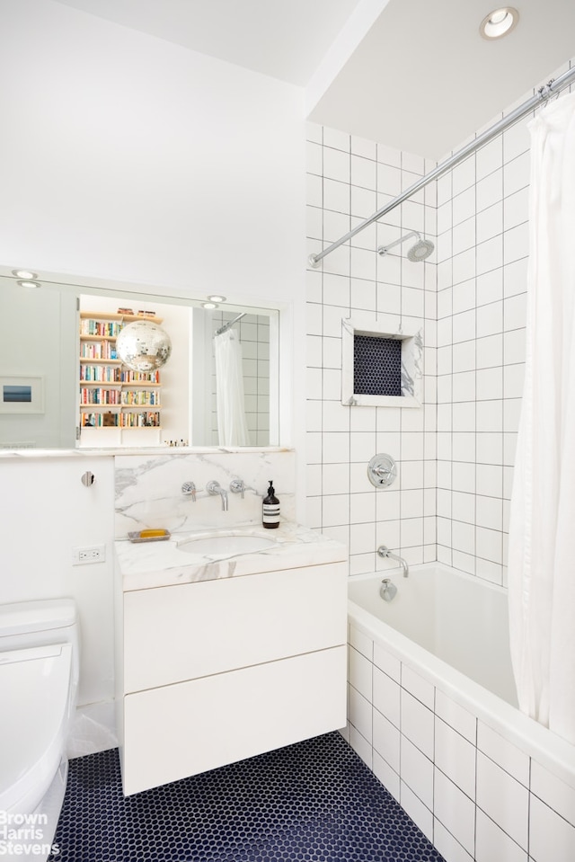 bathroom with tiled shower / bath combo, toilet, vanity, and tile patterned flooring