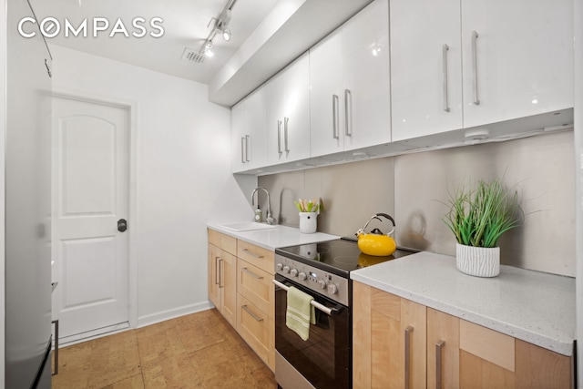 kitchen with visible vents, a sink, stainless steel electric range, white cabinets, and light stone countertops