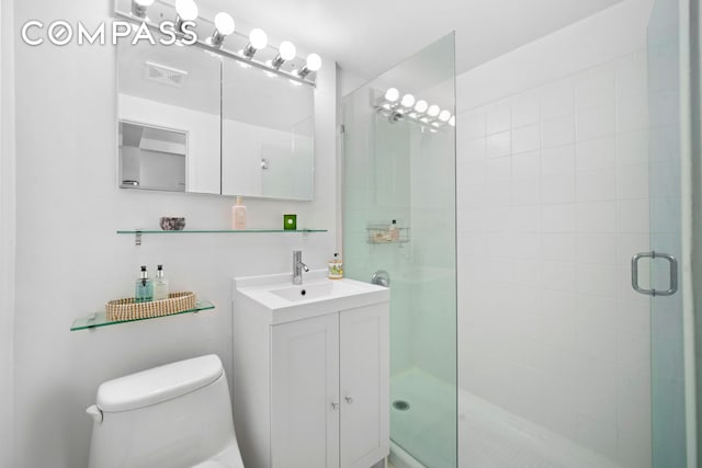 full bath with visible vents, a stall shower, toilet, and vanity