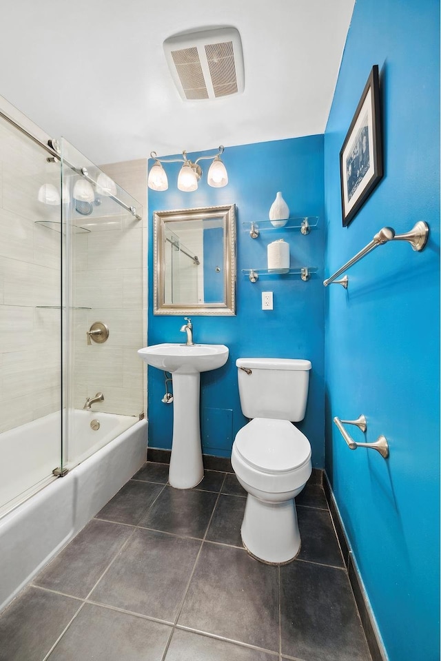 bathroom with visible vents, toilet, enclosed tub / shower combo, tile patterned flooring, and baseboards