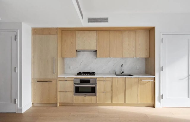 37-14 34th St Unit N-4C, New York City, NY 11101 - kitchen featuring appliances with stainless steel finishes, light brown cabinetry, a sink, tasteful backsplash, and light countertops