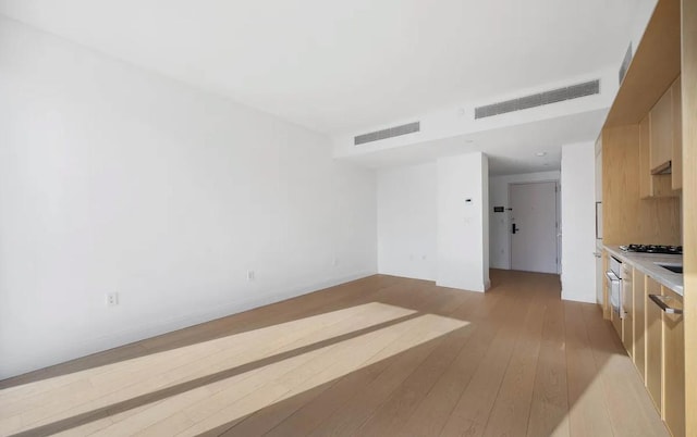 37-14 34th St Unit N-4C, New York City, NY 11101 - unfurnished living room featuring light wood finished floors and baseboards