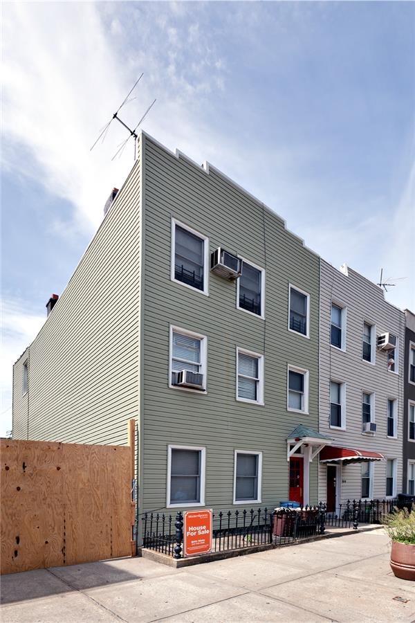 view of property with a wall mounted air conditioner, cooling unit, and fence
