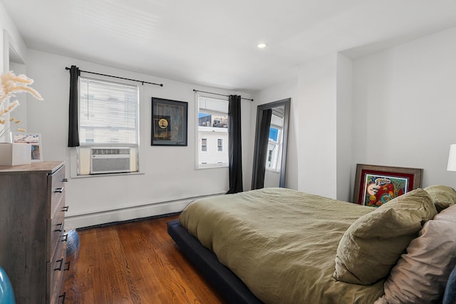 bedroom featuring dark wood-style floors, multiple windows, cooling unit, and a baseboard heating unit
