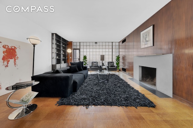 219 E 49th St, New York City, NY 10017 - living area with wood walls, built in shelves, and a fireplace with flush hearth