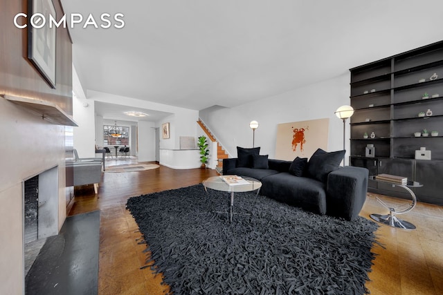 219 E 49th St, New York City, NY 10017 - living room with wood finished floors, a notable chandelier, stairs, and a fireplace