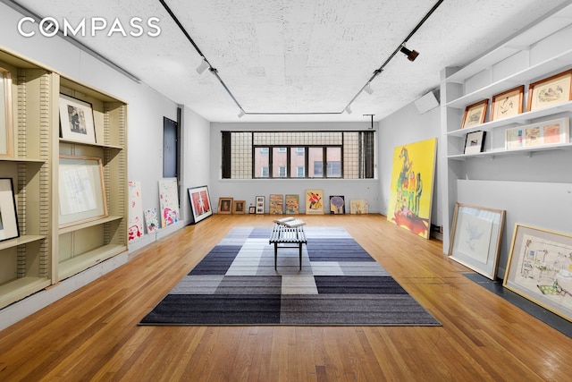 219 E 49th St, New York City, NY 10017 - game room with a textured ceiling, rail lighting, and wood finished floors