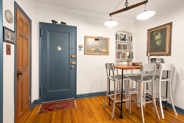 221 E 18th St Unit 6H, New York City, NY 11226 - dining area featuring wood finished floors, baseboards, ornamental molding, and built in shelves