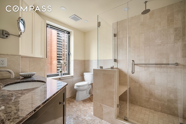 227 E 57th St Unit 18Bf, New York City, NY 10022 - bathroom with vanity, tile walls, a shower stall, wainscoting, and recessed lighting