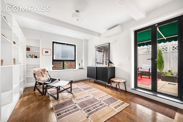 227 E 57th St Unit 18Bf, New York City, NY 10022 - sitting room with a wall unit AC, wood finished floors, beam ceiling, and built in shelves