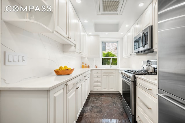 227 E 57th St Unit 18Bf, New York City, NY 10022 - kitchen featuring stainless steel appliances, white cabinets, recessed lighting, light stone countertops, and decorative backsplash